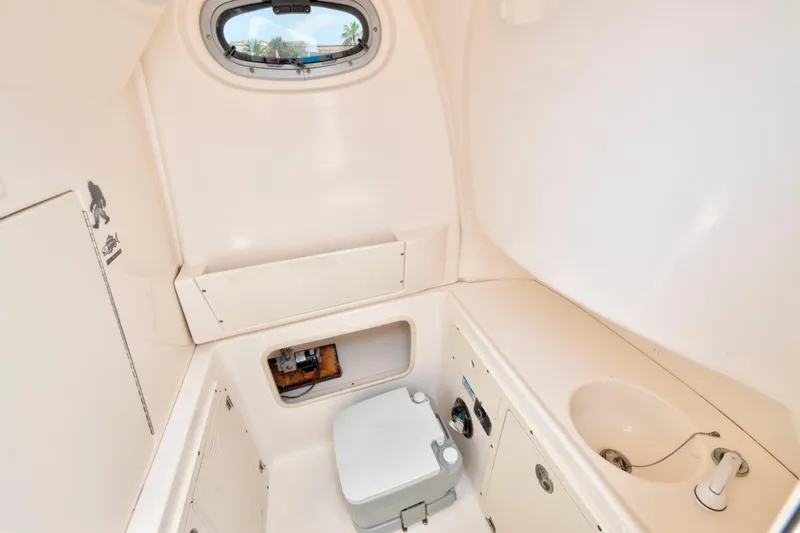 Slide: The Image of Interior of 2003 Boston Whaler 270 Outrage boat, featuring compact restroom amenities. - 17
