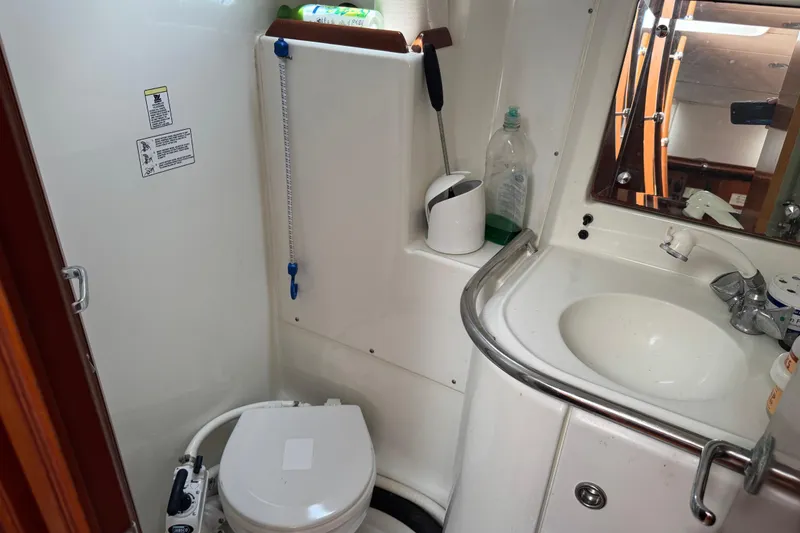 Slide: The Image of Bathroom of 1997 Beneteau Oceanis 461 yacht with toilet, sink, and mirror. - 14