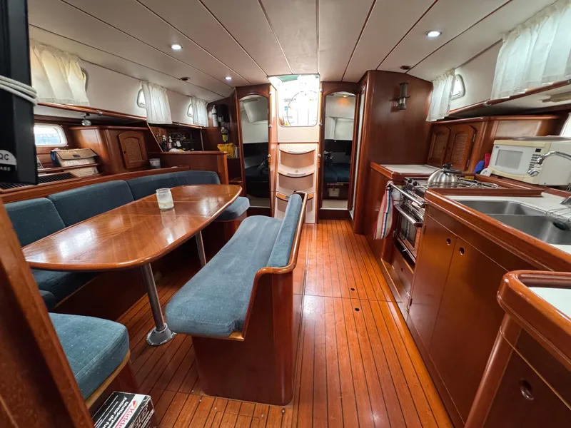 Slide: The Image of Interior of 1997 Beneteau Oceanis 461 yacht with wood finish and dining area. - 17