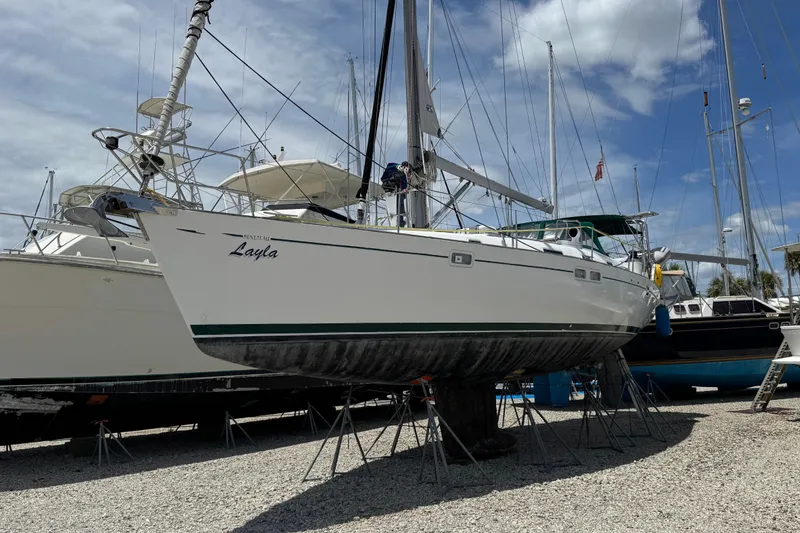 Slide: The Image of 1997 Beneteau Oceanis 461 sailboat on stands, named "Layla," under a partly cloudy sky. - 2