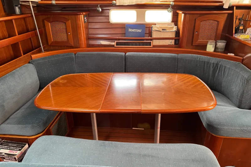Slide: The Image of Cozy interior of 1997 Beneteau Oceanis 461 sailboat with wooden table and blue seating. - 6