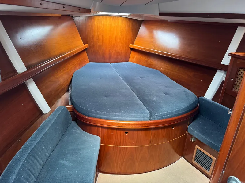 Slide: The Image of Interior cabin of 1997 Beneteau Oceanis 461 sailboat with wooden finish and blue upholstery. - 7