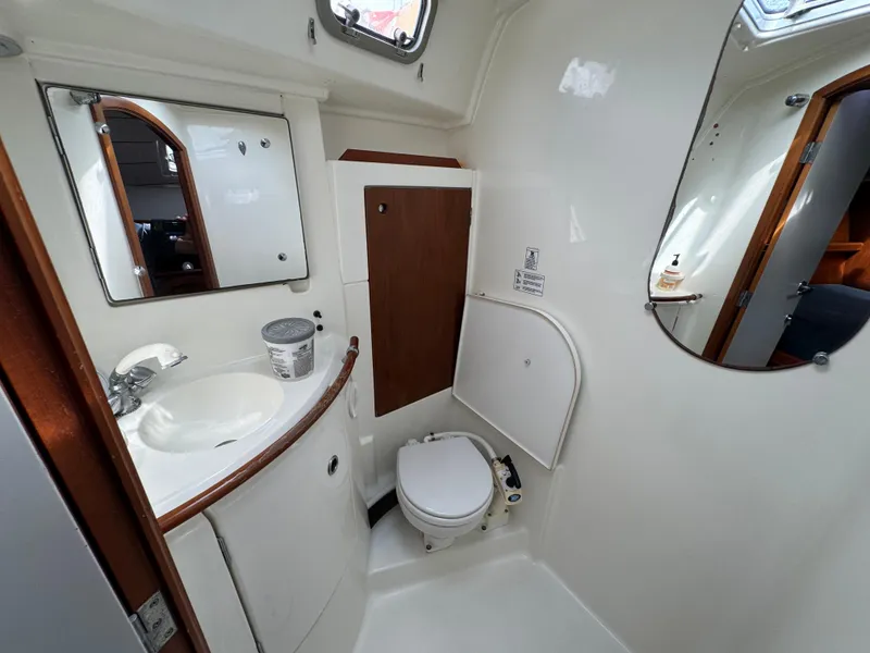 Slide: The Image of Bathroom interior of 1997 Beneteau Oceanis 461 yacht, featuring sink, toilet, and mirrors. - 9