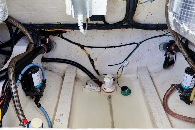 Slide: The Image of 2022 Cobia 301 Center Console bilge area with pumps and wiring. - 15