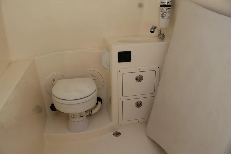 Slide: The Image of 2022 Cobia 301 Center Console boat interior with toilet and storage compartments. - 17