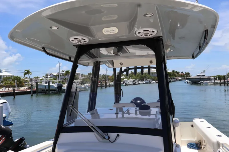 Slide: The Image of 2022 Cobia 301 Center Console boat docked in a scenic marina. - 18