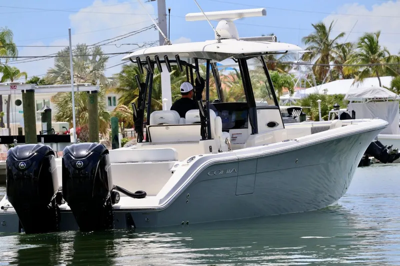Slide: The Image of 2022 Cobia 301 Center Console boat with dual engines on a sunny day. - 4