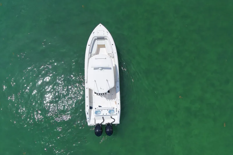 Slide: The Image of Overhead view of 2022 Cobia 301 Center Console boat on clear green water. - 5