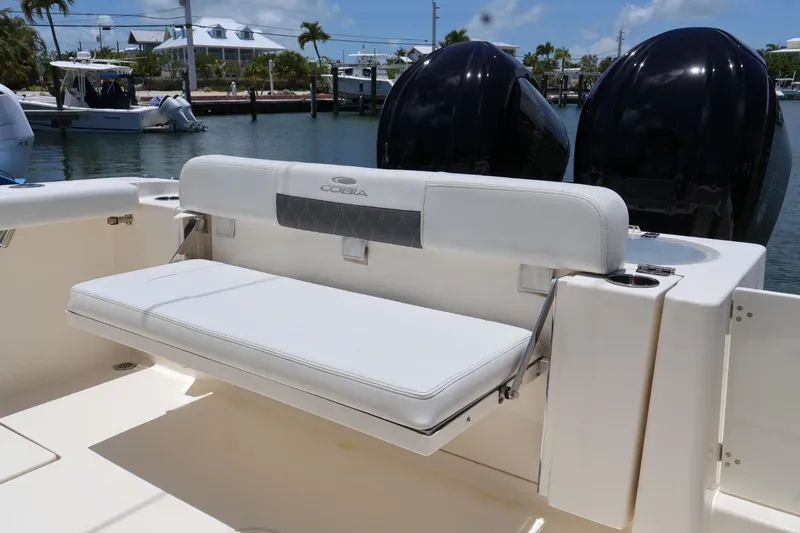 Slide: The Image of 2022 Cobia 301 Center Console boat with white seating and dual engines. - 7