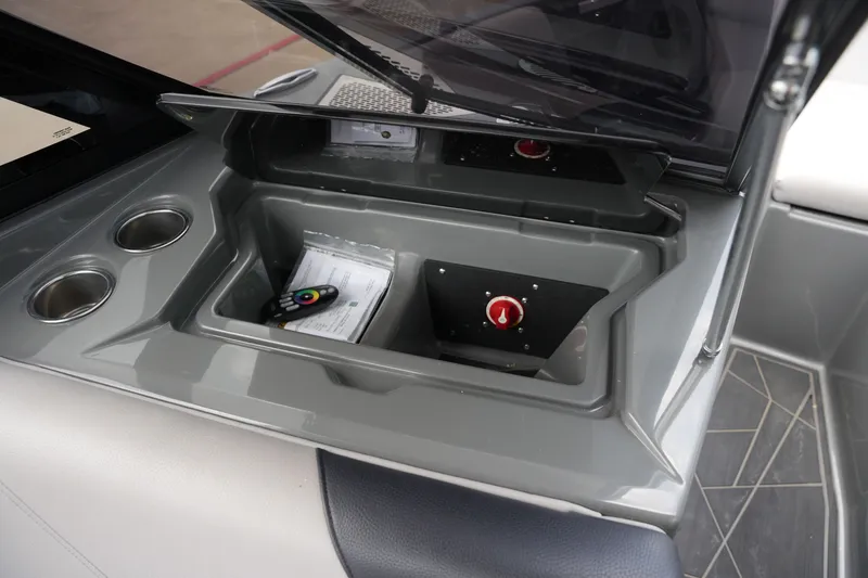 Slide: The Image of ATX 24 Type-S boat storage compartment with remote and cup holders. - 31