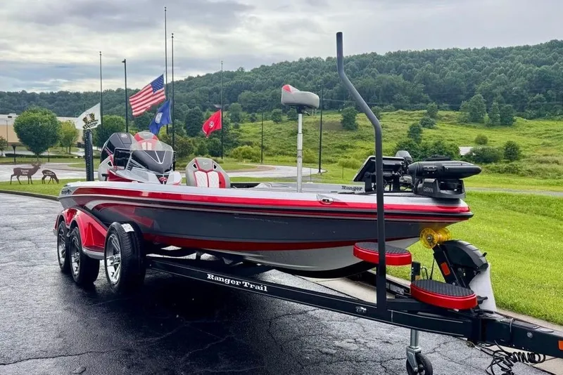 Slide: The Image of 2026 Ranger Z521R Cup-Equipped boat on trailer, parked outdoors with flags in background. - 1