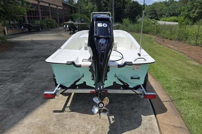 Slide: The Image of 2026 Mako Pro Skiff 17 CC with 60 HP engine on a trailer, parked outdoors. - 6