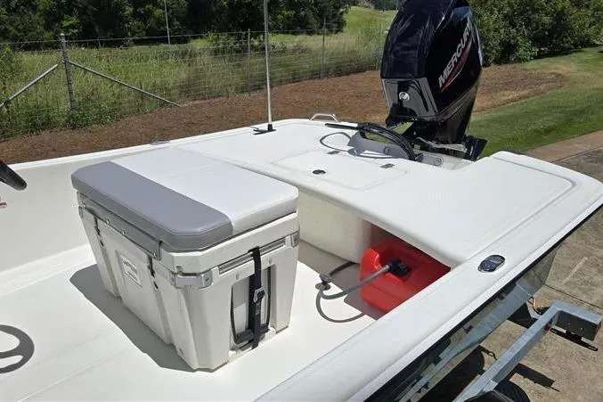 Slide: The Image of 2026 Mako Pro Skiff 17 CC boat with Mercury engine and cooler on deck. - 11
