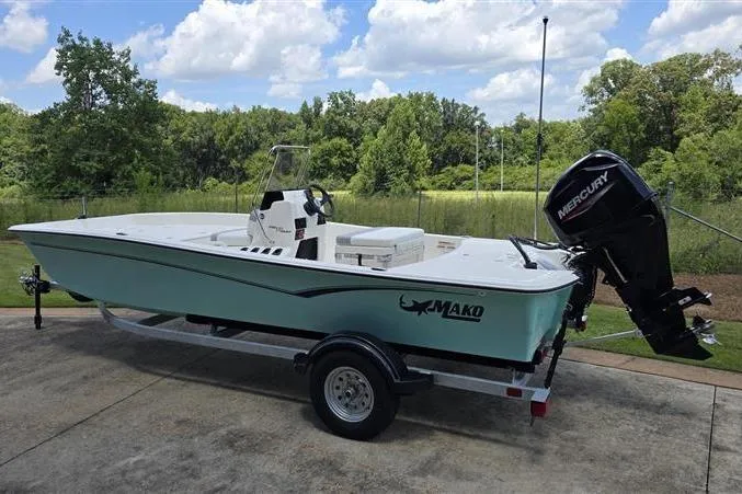 Slide: The Image of 2026 Mako Pro Skiff 17 CC boat on trailer, parked outdoors with scenic background. - 5