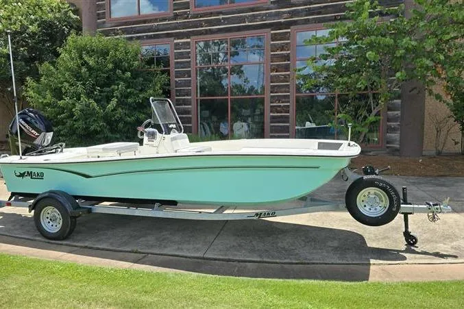 Slide: The Image of 2026 Mako Pro Skiff 17 CC boat on trailer, parked outdoors near building. - 1