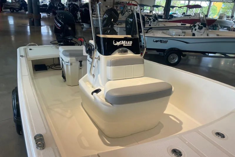 Slide: The Image of 2026 Mako Pro Skiff 15 CC boat interior with seating and console in showroom. - 4