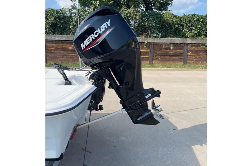 Slide: The Image of 2026 Mako Pro Skiff 15 CC with Mercury outboard motor, parked outdoors. - 3