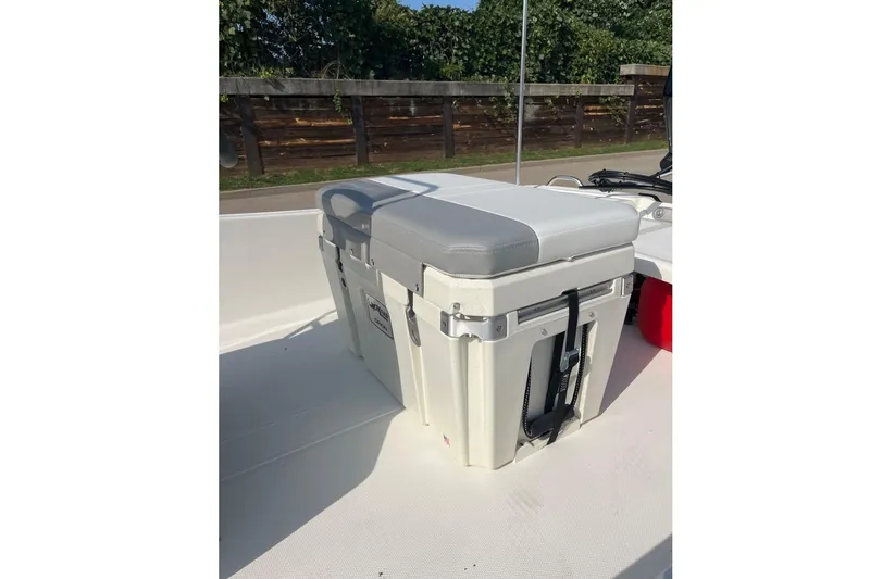 Slide: The Image of 2026 Mako Pro Skiff 15 CC boat with cushioned cooler seat on deck. - 2