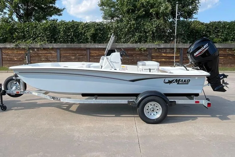 The Image of 2026 Mako Pro Skiff 15 CC boat on trailer, featuring Mercury outboard motor. - 0