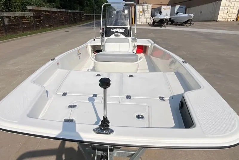 Slide: The Image of 2026 Mako Pro Skiff 15 CC boat on trailer, parked outdoors, showcasing spacious deck. - 1