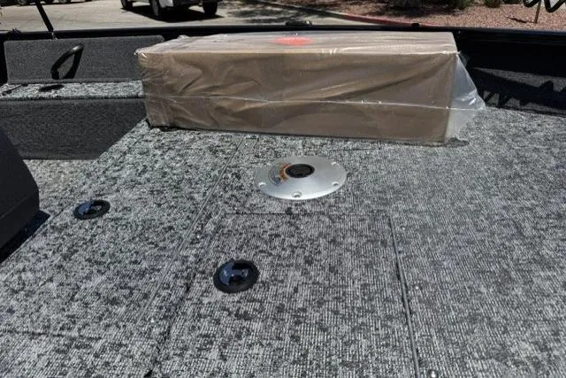 Slide: The Image of 2026 Tracker Pro Guide V-16 SC boat deck with packaged item on textured surface. - 9