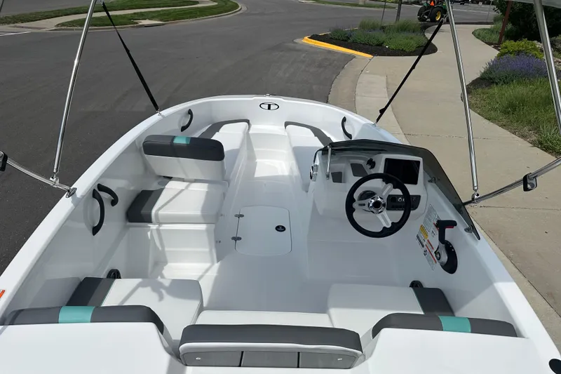 Slide: The Image of 2026 Tahoe T16 boat interior with modern steering and seating, parked on a street. - 9