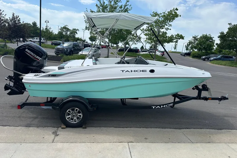 Slide: The Image of 2026 Tahoe T16 boat with canopy on trailer, parked outdoors. - 7