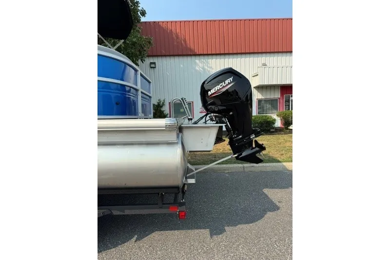 Slide: The Image of 2026 Sun Tracker Party Barge 20 DLX with Mercury outboard motor, parked outdoors. - 3