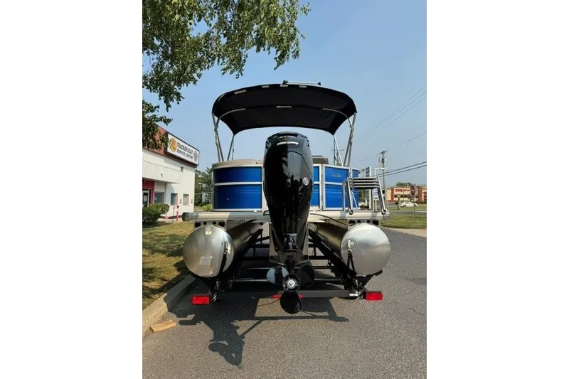 Slide: The Image of 2026 Sun Tracker Party Barge 20 DLX pontoon boat with outboard motor, parked on street. - 6