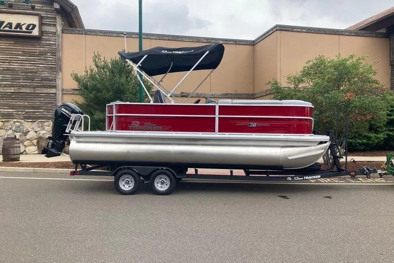 The Image of 2026 Sun Tracker Party Barge 20 DLX pontoon boat on trailer, parked outdoors. - 0