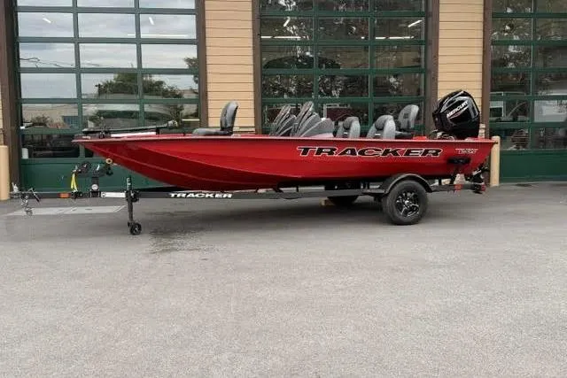 The Image of 2026 Tracker Pro Team 175 boat in vibrant red, parked outside a building. - 0