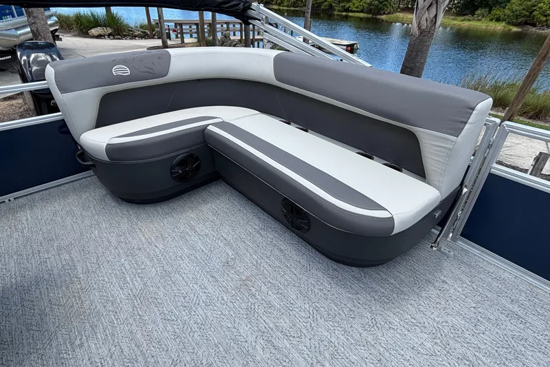 Slide: The Image of 2026 Sun Tracker Bass Buggy 16 XL Select pontoon boat seating area by a lake. - 15