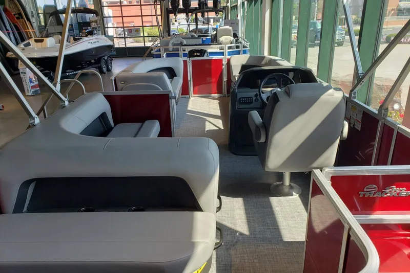 Slide: The Image of 2026 Sun Tracker Party Barge 18 DLX interior with seating and steering console. - 3
