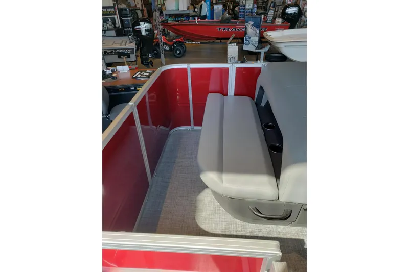 Slide: The Image of 2026 Sun Tracker Party Barge 18 DLX interior with red paneling and gray seating. - 7