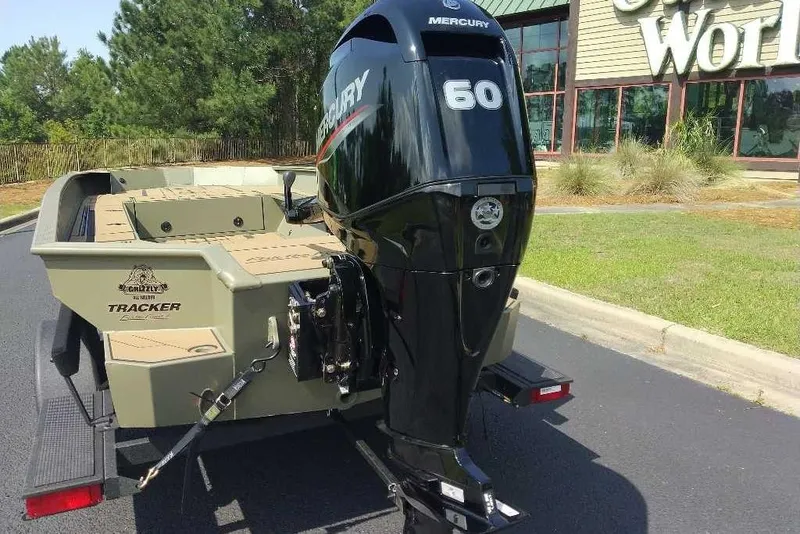 Slide: The Image of 2026 Tracker Grizzly 1756 T Marsh boat with Mercury 60 engine, parked outdoors. - 14