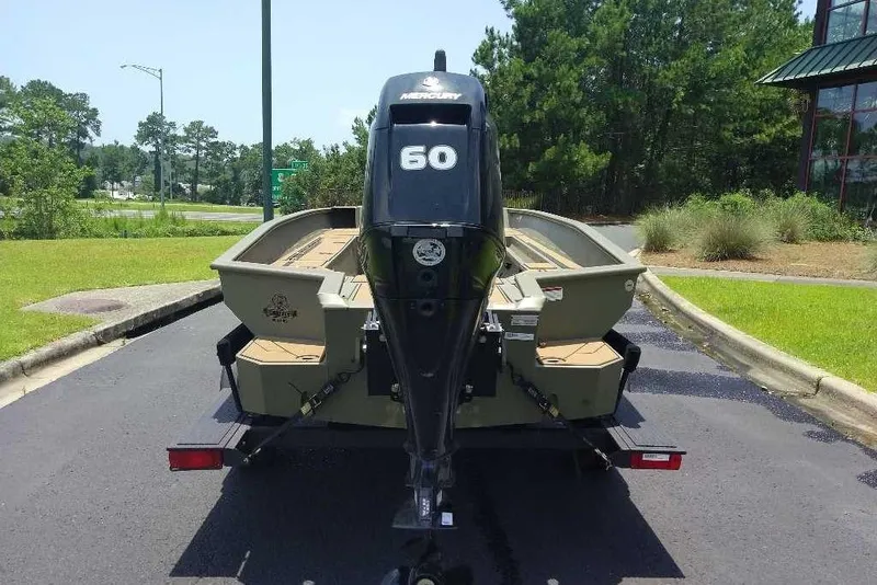 Slide: The Image of 2026 Tracker Grizzly 1756 T Marsh boat with Mercury 60 engine, parked outdoors. - 2