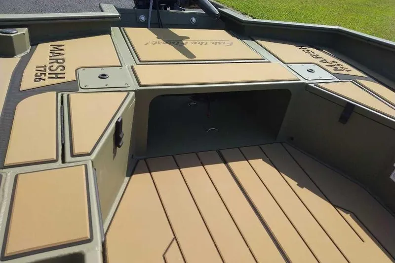 Slide: The Image of 2026 Tracker Grizzly 1756 T Marsh boat interior with tan deck and storage compartments. - 7