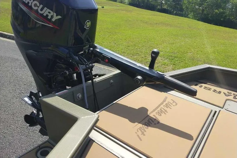 Slide: The Image of 2026 Tracker Grizzly 1756 T Marsh boat with Mercury outboard motor on grassy background. - 8