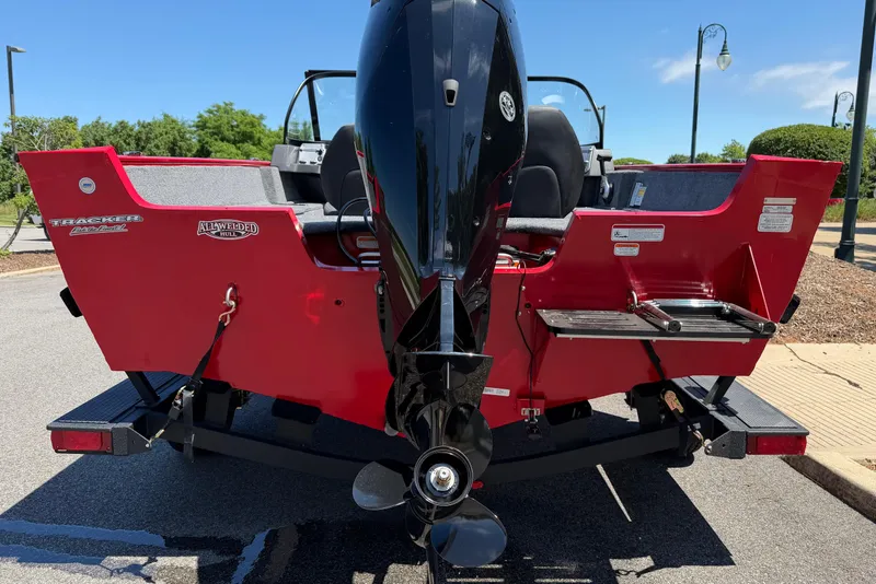 Slide: The Image of 2026 Tracker Pro Guide V-175 WT boat, red exterior, parked on a trailer, rear view. - 6