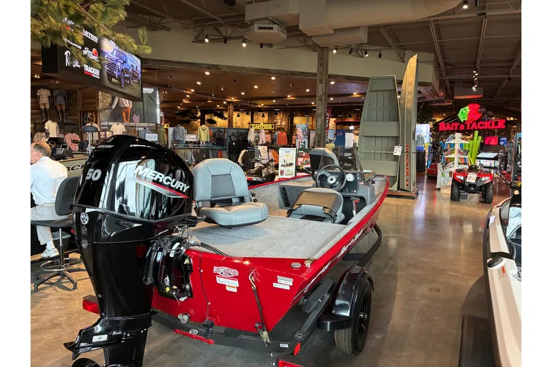 Slide: The Image of 2026 Tracker Bass Tracker Classic XL boat displayed indoors with Mercury engine. - 2
