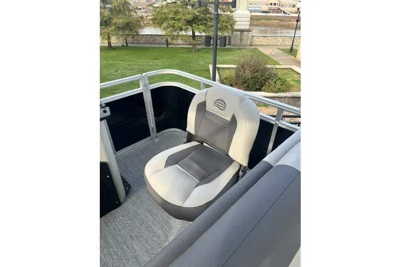 Slide: The Image of 2026 Sun Tracker Fishin' Barge 20 DLX boat seat, gray and white, near waterfront park. - 9