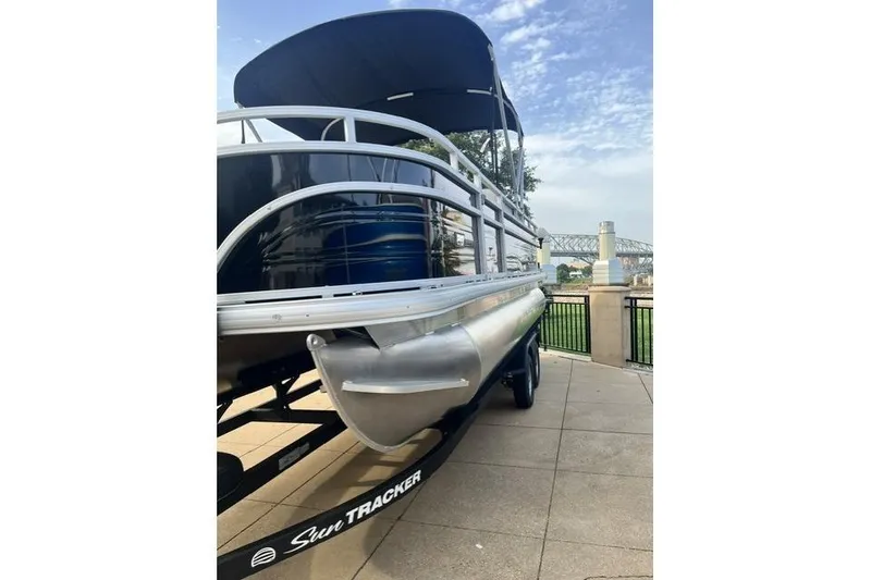 Slide: The Image of 2026 Sun Tracker Fishin' Barge 20 DLX pontoon boat on trailer, scenic background. - 6