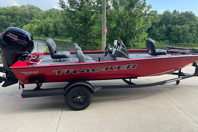 Slide: The Image of 2026 Tracker Pro Team 190 boat on trailer, red exterior, parked near a lake. - 5