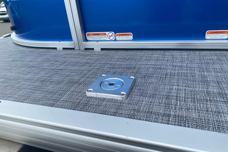 Slide: The Image of 2026 Sun Tracker Party Barge 20 DLX deck with blue panel and metal fixture. - 4