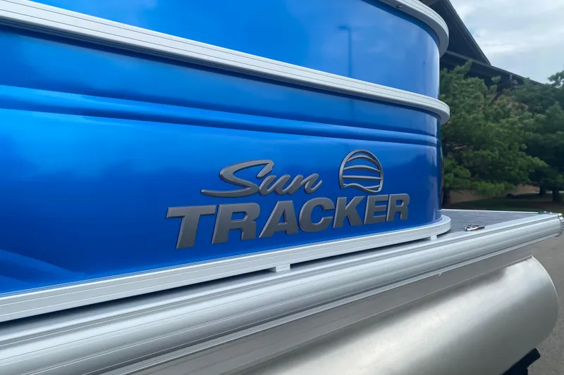 Slide: The Image of 2026 Sun Tracker Party Barge 20 DLX pontoon boat with blue exterior detailing. - 2