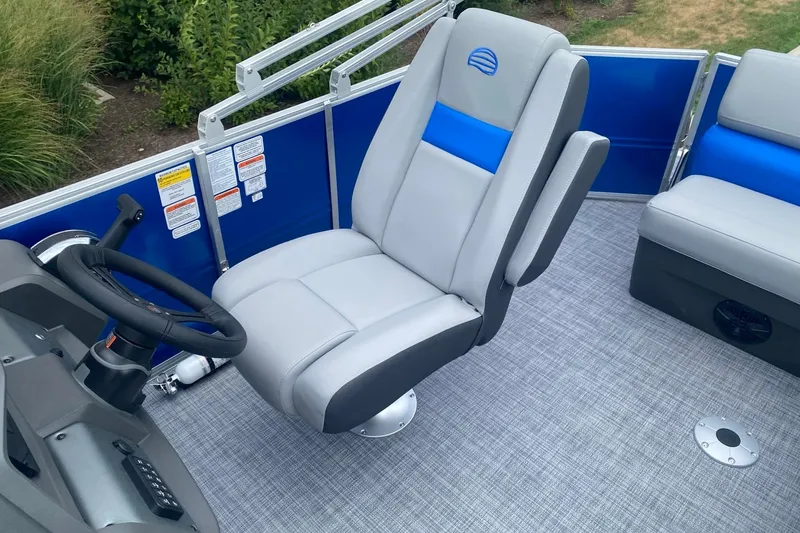 Slide: The Image of 2026 Sun Tracker Party Barge 20 DLX interior with gray captain's chair and steering wheel. - 5