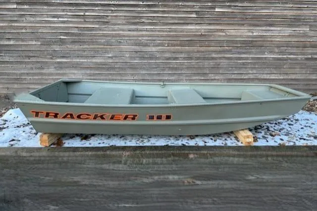 The Image of 2026 Tracker Grizzly 10 Jon boat displayed outdoors on wooden supports. - 0