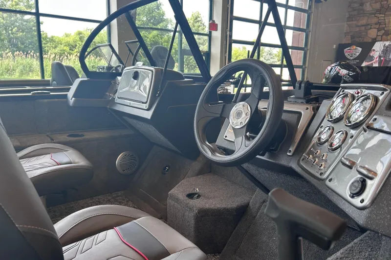 Slide: The Image of Interior of 2026 Tracker Pro Guide V-175 WT boat with steering wheel and dashboard controls. - 5