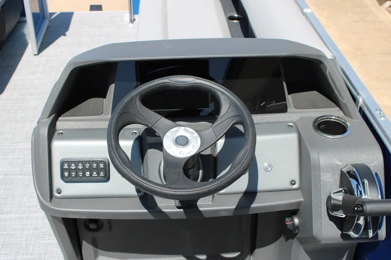 Slide: The Image of 2026 Sun Tracker Party Barge 18 DLX steering console with controls and cup holder. - 11