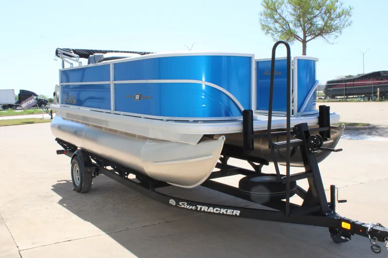 Slide: The Image of A blue Sun Tracker Party Barge 18 DLX pontoon boat from 2026 on a trailer. - 4